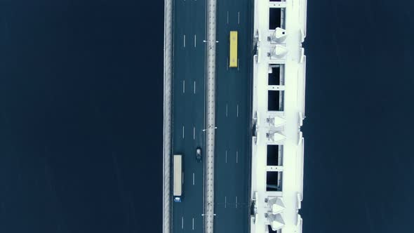 Aerial View Vertically Down the Road Bridge in Winter in Snowfall Over the Bay alt