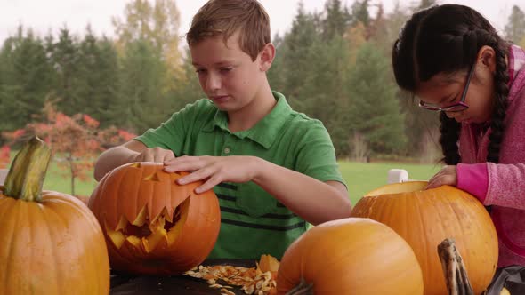 Kids carving pumpkins for Halloween