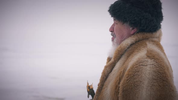 Side View Portrait of Senior Bearded Man Walking at Background of Frozen Northern Ocean alt