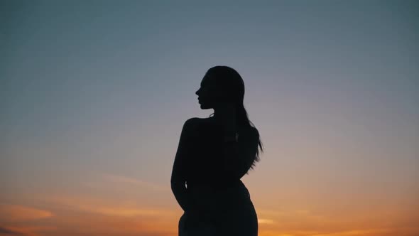 Girl on the Background of the Sky at Sunset