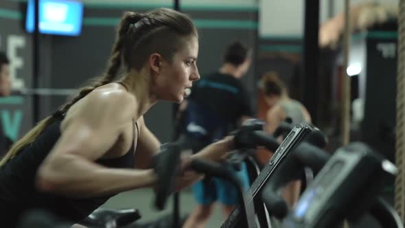 A Beautiful Sportswoman Girl Trains on an Air Bike Exercise Bike in the Gym Professional Athlete in alt