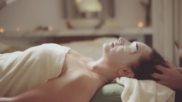 Young Beautiful Caucasian Woman Lying on a Spa Bed Receiving a Lip Massage with Skin Care with alt