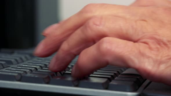 Old Caucasian Woman Works on Computer in Home - Closeup of Fingers and Keyboard alt
