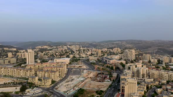 Aerial forward fly shot of Jerusalem's Chords Bridge and the city entrance area, Israel alt
