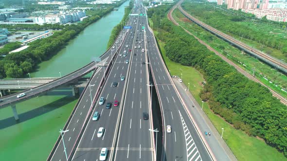 Aerial View of a Highway Overpass Multilevel Junction with Fast Moving Cars Surrounded By Green alt
