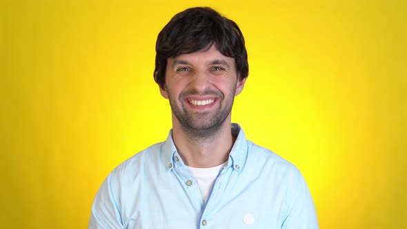 Handsome Smiling Man Isolated on Yellow Background in Studio alt