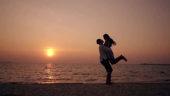 Girl Silhouette Runs and Jumps Hugs Man at Sea Slow Motion alt