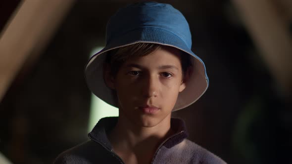 Portrait of a Sad Serious Boy in Hat Looking at the Camera, Indoors