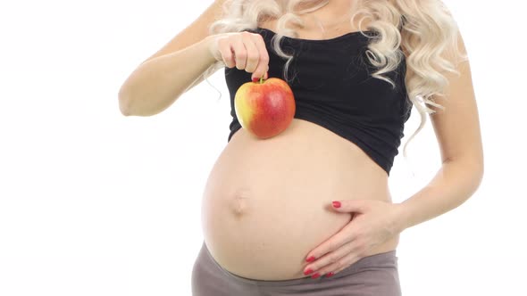 Pregnant Woman with a Red Apple on Her Belly, White, Closeup alt