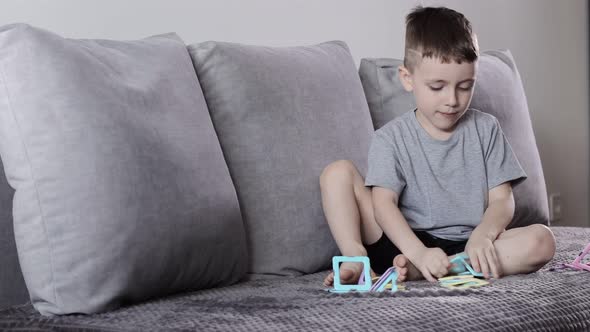 A little boy gaming with magnetic constructor. Creativity development. Magnetic constructor. alt
