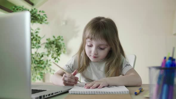 Cheerful Cute Preschool Child Little Girl Kid Drawing on Paper Using Laptop alt