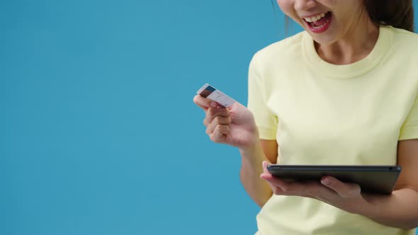 Young Asia lady using tablet and credit bank card with positive expression.