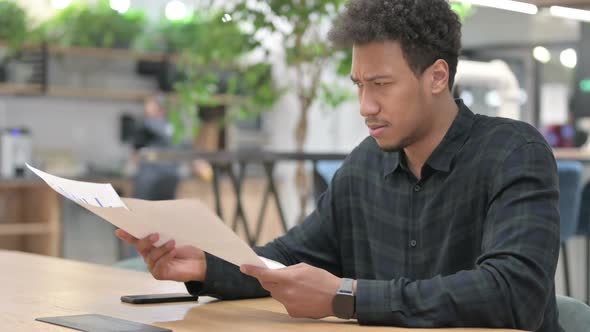African American Man Having Loss While Reading Documents alt