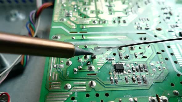 Slow motion close up shot eletric solder in soldering on eletronic print circult board with hot lead alt