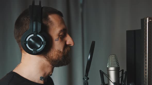 Closeup Indoor Shot of a Male Caucasian Music Artist Recording His New Album at the Studio Using alt