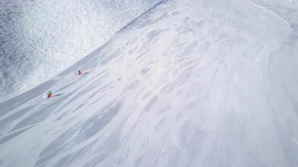 Aerial View Following Two Skiers on Piste