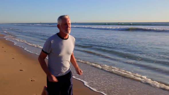 Senior Man Exercising At The  Beach alt
