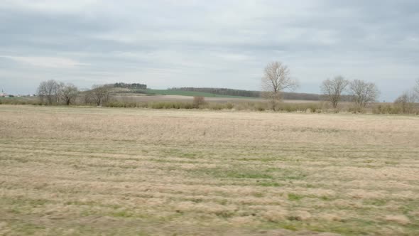 Side view of Ride Through the early spring landscape with plain and fields,