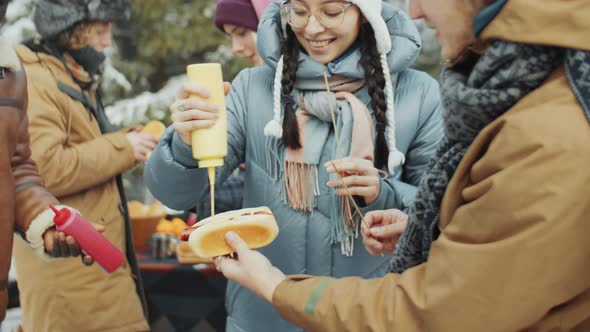 Friends Cooking BBQ Hot Dogs at Campsite in Winter alt