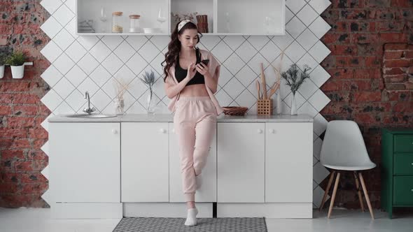 Young European Woman Is Using Phone for Video Call While Standing in Home Kitchen.