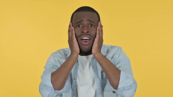 Young African Man Reacting to Loss Yellow Background alt