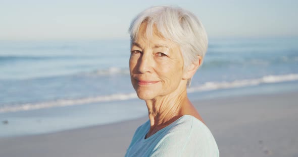 Senior Caucasian woman enjoying time at the beach with sea in the background alt