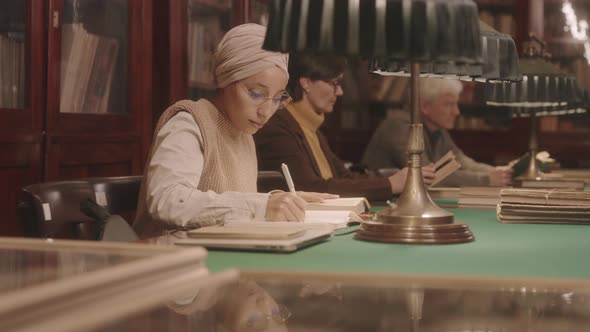 Muslim Female Student Studying in Library alt