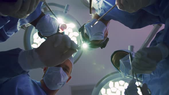 Upward view of Multi-ethnic Surgeons performing surgery in operation theater at hospital alt