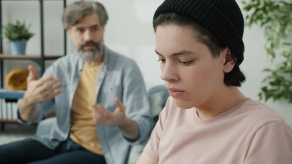 Caring Dad Talking To Stubborn Teenager Who Is Ignoring Parent Feeling Offended Sitting at Home alt