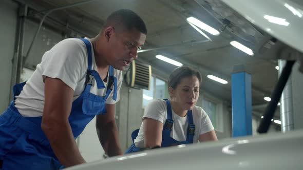 Slow Motion, Technician Explains How To Repair the Car To Colleague 