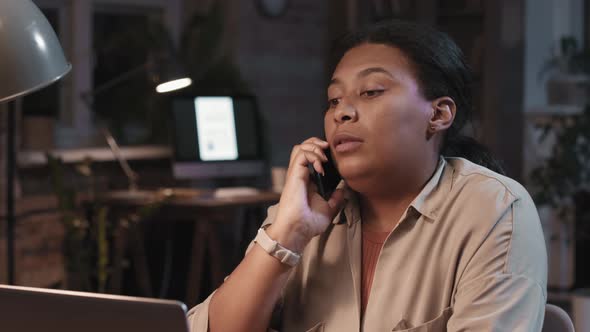 Afro Woman Having Phone Call In Office At Night alt