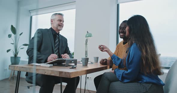 Couple looking excited and happy getting new house keys from realtor alt