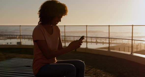 Woman using phone at sunset  alt