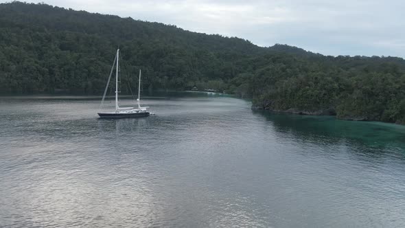 Aerial View Of Triton Bay: Boat On Turquoise Sea And Green Tropical Trees In Kaimana Islands.  alt