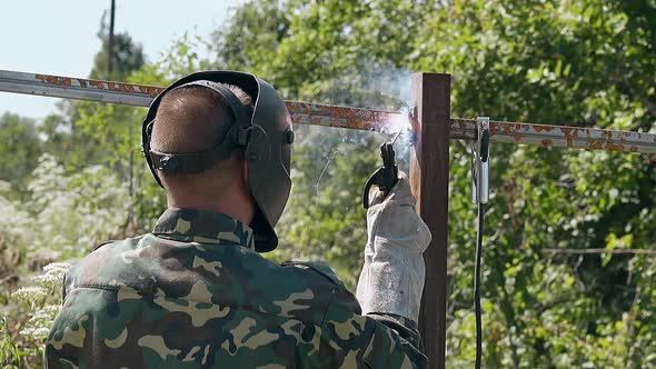 Slow Motion Backside Man Builds Fence Using Tool at Sparks alt