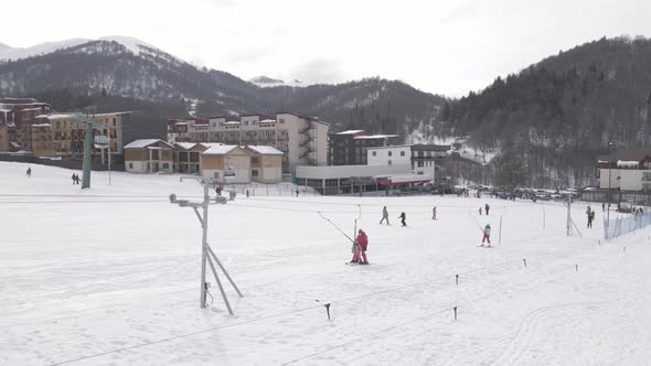 Flying over Skiers skiing climb a yoke on a mountain. people going skiing and snowboarding alt