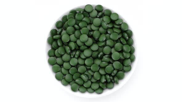 superfoods Spirulina, chlorella supplement green pills top view rotation alt