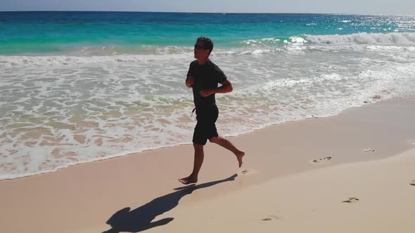 Healthy Lifestyle Young Man Runner Running on Sea