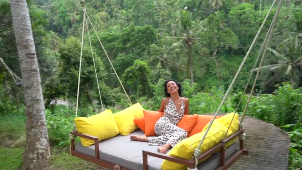 Happy Woman Enjoying Cosy Flying Bed Swing in the Rainforest Pure Happiness on Tropical Summer alt