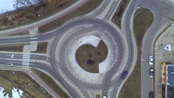 AERIAL: Slowly Rising Above Roundabout While Motor Vehicles Enters and Exits It alt