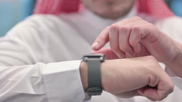 Close up of Middle Aged Arab Man using Smart Watch alt