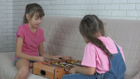 Child play board game. Two friends play a table football. alt
