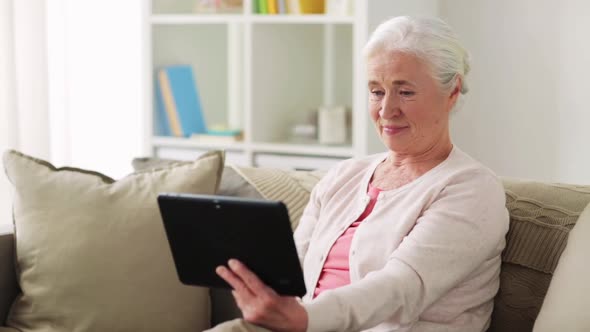 Old Woman with Tablet Pc Having Video Call at Home alt