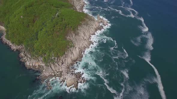 View From a Drone Vertically Down on a Stone Cape Washed By Strong Waves alt