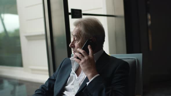 Businessman Seriously Talking on a Mobile Phone
