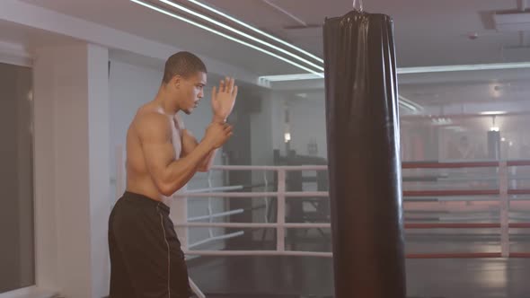 Selfimprovement Athletic Man Fighter Trains His Punches Beats a Punching Bag Training Day in the alt