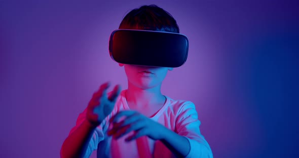 Boy Wearing VR Glasses Playing Game Under Neon Lights