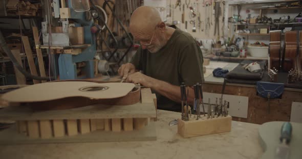 Luthier filing a guitar mold