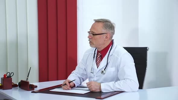 Male doctor speaks with patient in office. Physician at work. alt