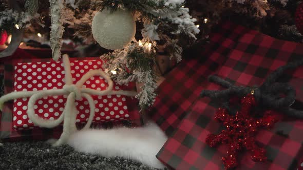 Panning view of presents wrapped under a christmas tree alt